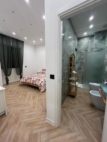 a bedroom with a bed and a bathroom with a sink at affittacamerecoppola in Angri
