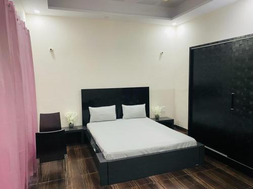 a bedroom with a bed with a black headboard at The Nest spacious and homely flat in Haldwani in Haldwāni