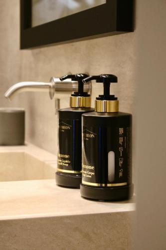two soap dispensers sitting on a bathroom sink at Palazzo Goldoni Condotti Collection in Rome