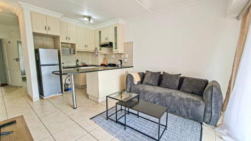 a living room with a couch and a kitchen at Villa Moya 46 in Margate
