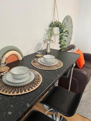 a black table with plates and dishes on it at 8 person 4 bedroom 4en-suite Free Parking in Warwick