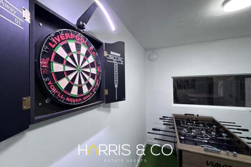 a dart board on a wall next to a stove at Sandringham & Spa Villa in Thornton