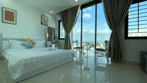 ein weißes Schlafzimmer mit einem Bett und einem Tisch und Stühlen in der Unterkunft Ruby Star Hotel Apartment in Vũng Tàu