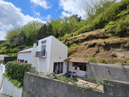 a white house on the side of a hill at Paradise House Furnas in Furnas