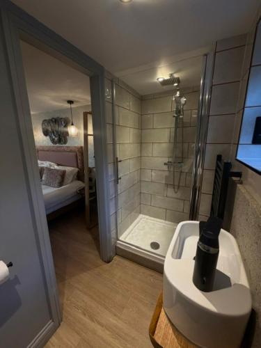 a bathroom with a shower and a white sink at Rylands Farm Guest House in Wilmslow
