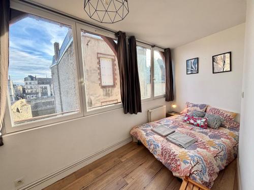 拉瓦勒Vue Château & Mayenne - Centre historique - 6 personnes的一间卧室设有一张床和两个大窗户