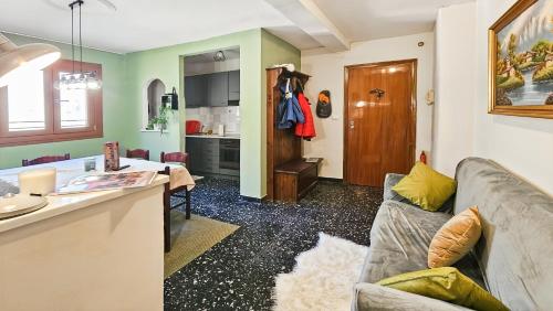 un salon avec un canapé et une cuisine dans l'établissement Limone Piemonte Kids Friendly, à Limone Piemonte