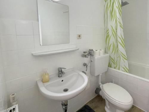 a white bathroom with a toilet and a sink at Work & Stay in Neuss in Neuss
