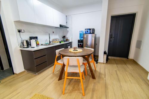 a small kitchen with a table and chairs in a room at Westlands Nairobi, Marina Bay, 1 Bedroom Apartment, Swimming Pool, Gym, Workspace, JW Homes in Nairobi