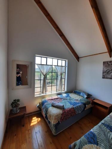 a bedroom with a bed and a window at Vellies Getaway in Buffelspoort
