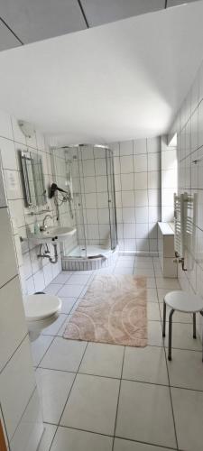 a white bathroom with a sink and a mirror at Urfter Hof Garni in Kall