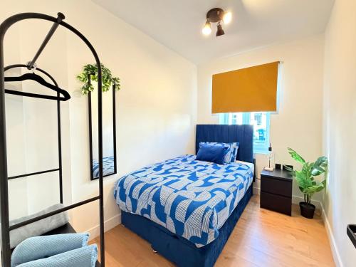 een slaapkamer met een bed met een blauw dekbed bij Spacious Preston Circus Flat - Great for Family, Group, Couples - Close to Station in Brighton & Hove