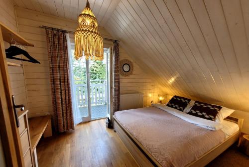 a bedroom with a bed and a chandelier at Tabaszówka in Krynica Zdrój
