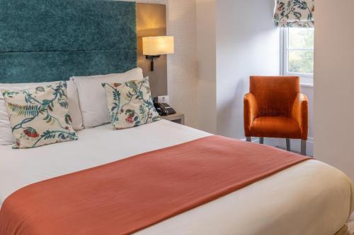 a hotel room with a bed and a chair at Best Western Abbots Barton Hotel in Canterbury