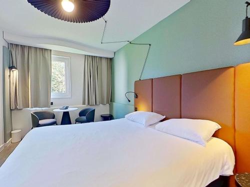 ein Schlafzimmer mit einem großen weißen Bett und Stühlen in der Unterkunft ibis Vannes in Vannes