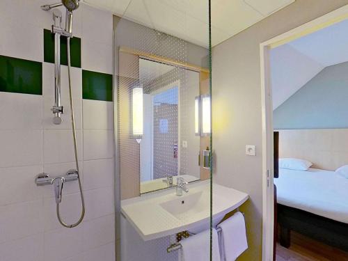 ein Badezimmer mit Waschbecken und Dusche in der Unterkunft ibis Vannes in Vannes