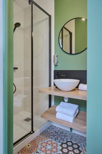 a bathroom with a sink and a glass shower at The Originals City, Le Beaujoire, Nantes - En face du Parc des Expositions et face au Stade Beaujoire in Nantes