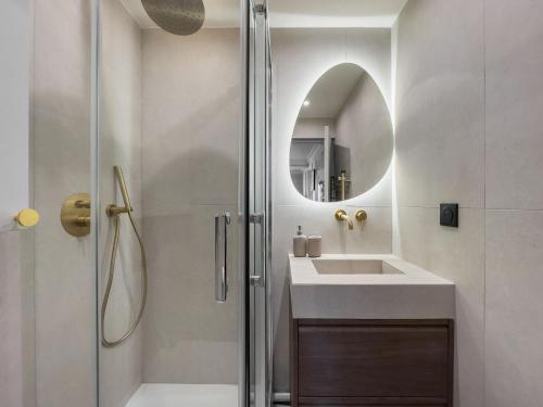 a bathroom with a sink and a shower with a mirror at PoeticStay - Neuilly in Neuilly-sur-Seine