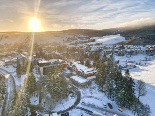 une ville sous la neige avec le soleil couchant dans l'établissement Summit of Saxony Resort Oberwiesenthal, à Kurort Oberwiesenthal