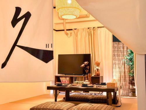 a living room with a tv and a table at 久Hisashi 池下10号店 Nagoya in Nagoya