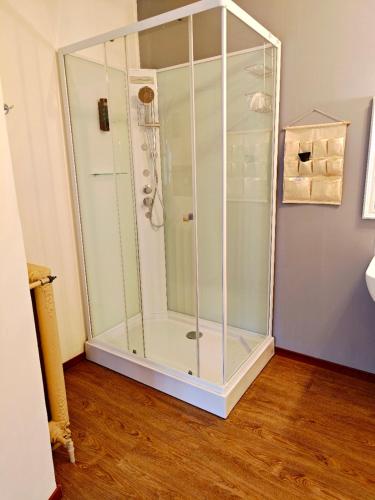 a glass shower in a room with a wooden floor at Antica Dimora in Bergamo