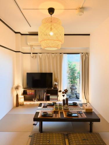 a living room with a table and a television at 久Hisashi 池下10号店 Nagoya in Nagoya