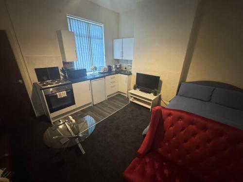 a room with a kitchen with a bed and a couch at Snug Studio - Minutes Walking from Pleasure Beach - Burlington Road in Blackpool