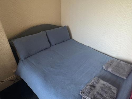 a bed with blue sheets and pillows in a room at Snug Studio - Minutes Walking from Pleasure Beach - Burlington Road in Blackpool