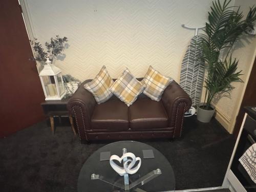 a living room with a brown couch with pillows at Snug Studio - Minutes Walking from Pleasure Beach - Burlington Road in Blackpool