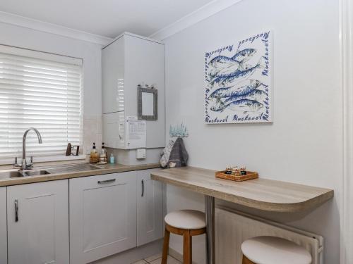 una cucina con lavandino e bancone con sgabelli di 8 Thurlestone Rock a Hope Cove