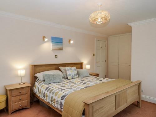 una camera da letto con un letto e un lampadario di 8 Thurlestone Rock a Hope Cove