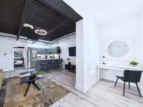 a living room with white walls and a table and chairs at Minutes to Port! Loft Near Dining & Fun -Unit 207 in Cape Canaveral