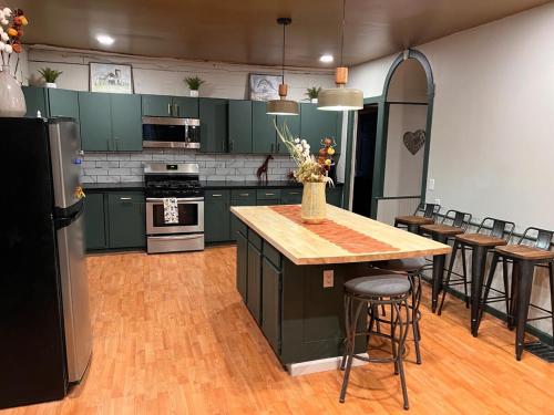 une cuisine avec des armoires vertes et une table et des chaises dans l'établissement Naples Wine Country 5BR Hot Tub Close to Bristol Mountain Skiing, à Naples