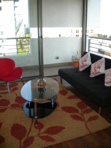 a living room with a couch and a glass table at Barceló Suites Providencia I in Santiago