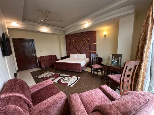 ein Hotelzimmer mit einem Bett und einer Couch in der Unterkunft Ambassador Inn in Islamabad