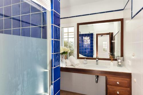 ein Badezimmer mit Waschbecken und Spiegel in der Unterkunft Casa con piscina y gran jardín in Colònia de Sant Pere