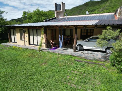 a woman is sitting in front of a house at El Silencio 2 - Quebrada - Lozano - Yala - Jujuy in Lozano