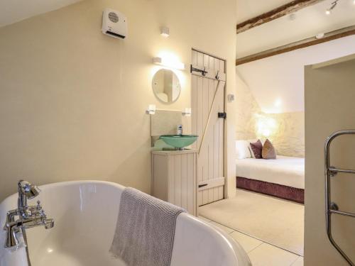 une salle de bain avec baignoire et une chambre dans l'établissement 1 Fron Uchaf, à Frongoch