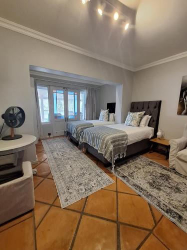 a bedroom with two beds and a living room at Whispering Waters Malgas in Malgas
