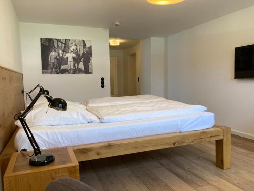 ein Schlafzimmer mit einem Bett und einem Schreibtisch mit Lampe in der Unterkunft Hof Hallenberg in Hallenberg