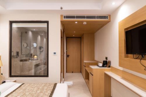 新德里Hotel The L D Casa Near International airport的一间配有床和平板电视的酒店房间