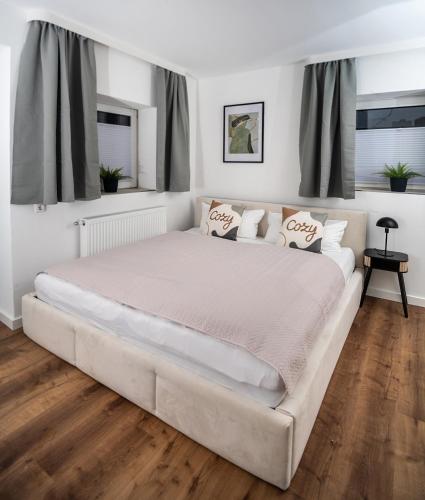 a large white bed in a bedroom with windows at Cozy 9 in Hamburg