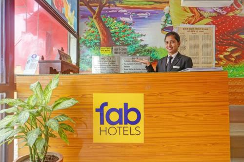 Ein Mann steht hinter einem Tresen mit einem Schild von Aici Hotels. in der Unterkunft Via Yadhuvanshi Dhaam - 900m from Prem Mandir and Iskcon Temple in Vrindāvan