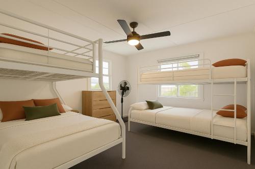 a bedroom with two bunk beds and a ceiling fan at Renovated 3-Bedroom Beach House - Sleeps 9 in Golden Beach
