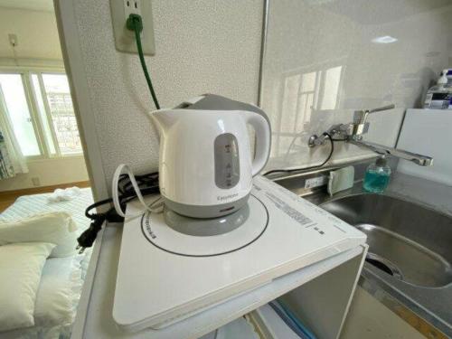 un frullatore bianco seduto sopra un bancone della cucina di Tokyo downtown芍藥莊 a Tokyo