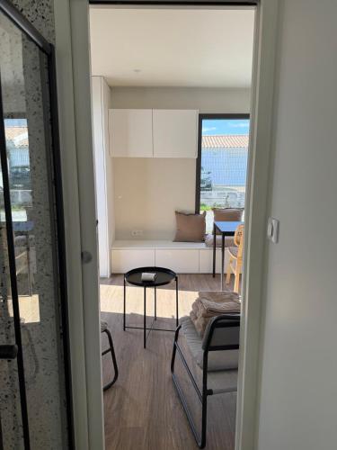 un salon avec un canapé et une table dans l'établissement Le 1000 fleurs studio neuf à 3 kms de La Rochelle, à Nieul-sur-Mer