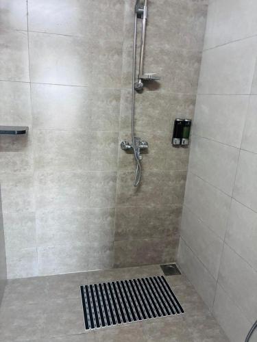 a bathroom with a shower with a black grate at Hotel Apartment Majestic Manor Dakar Diamniadio in Rufisque