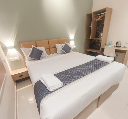 Un dormitorio con una cama grande con dos almohadas. en Elegant Residency, en Coimbatore