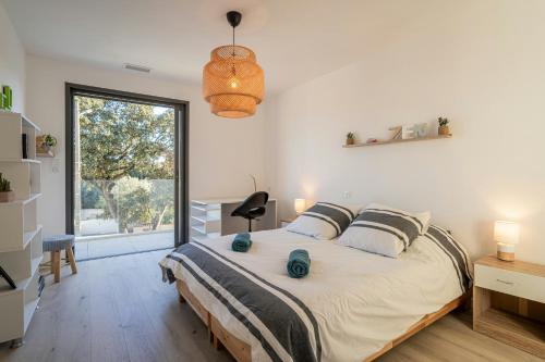 ein Schlafzimmer mit einem großen Bett und einem großen Fenster in der Unterkunft Modern Villa With Pool In Castelnau-Le-Lez in Castelnau-le-Lez