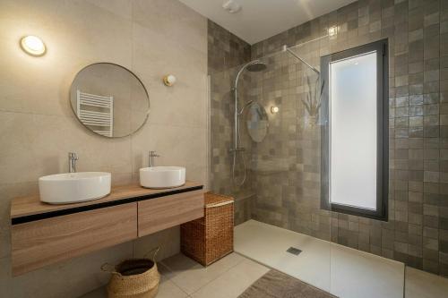ein Badezimmer mit zwei Waschbecken und einem Spiegel und einer Dusche in der Unterkunft Modern Villa With Pool In Castelnau-Le-Lez in Castelnau-le-Lez